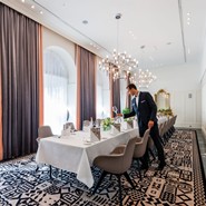 Mitarbeiter deckt einen eleganten Tisch im Le Salon des Hotels Sans Souci.