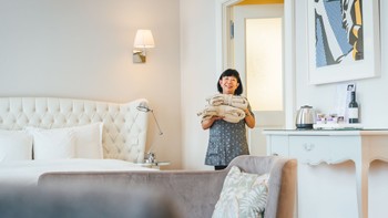 Employee with towels in the hotel room in Sans Souci Vienna.
